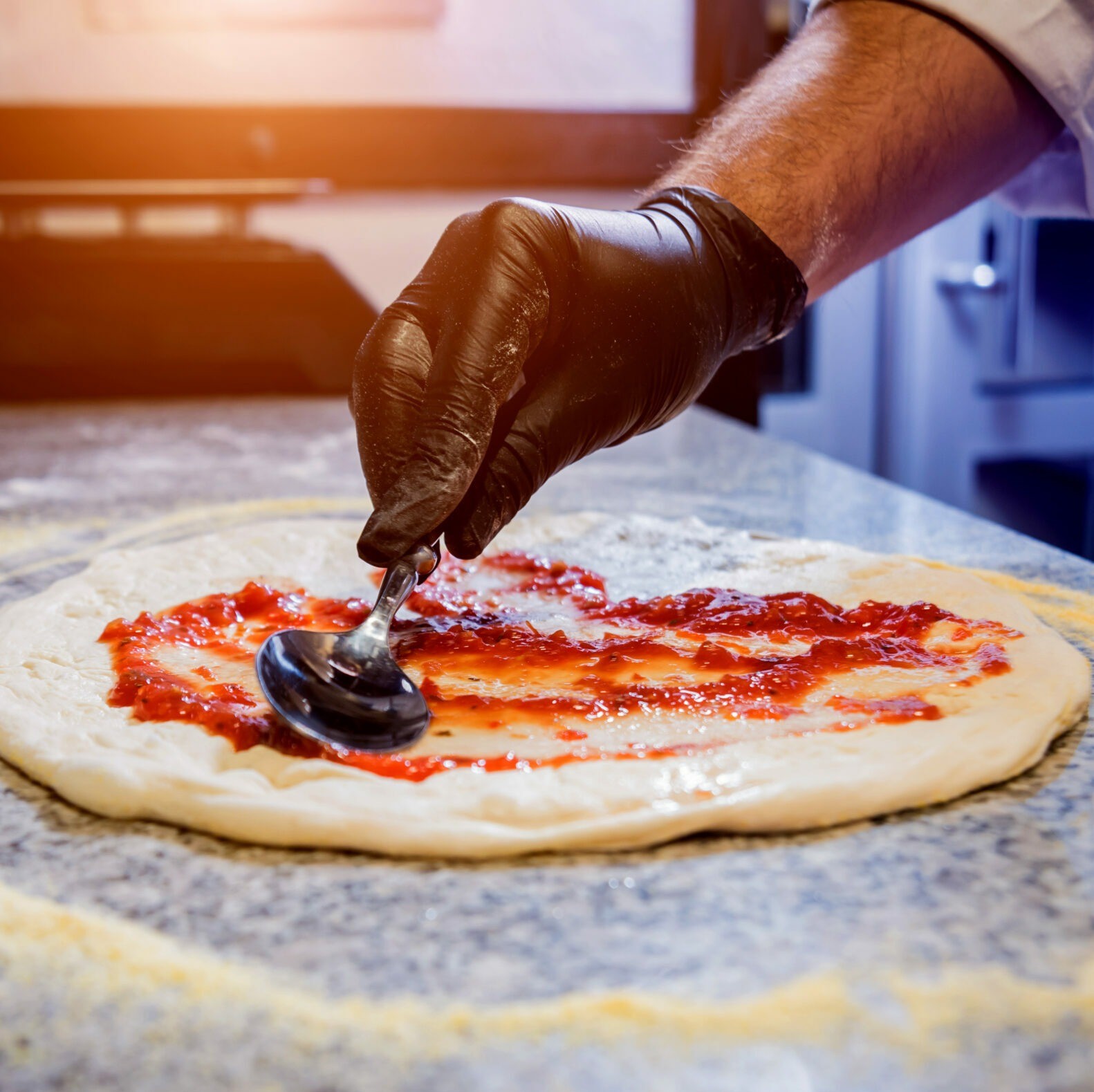 The process of making pizza. Hands of chef baker making pizza at cafe kitchen